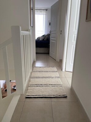 Enter a serene bedroom with a comfortable bed and a stylish rug leading the way.
