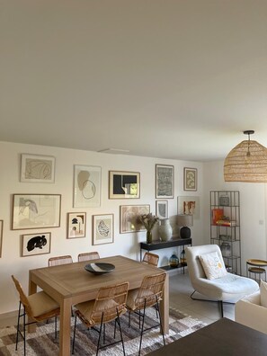 Relax in a stylish space with a dining table, wicker chairs, and artwork on the walls.