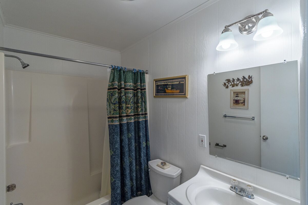 Un baño con ducha, inodoro y lavabo.