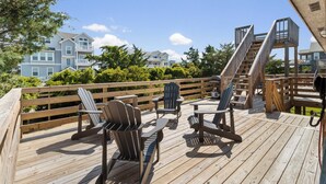 Un pontile in legno con poltrone Adirondack e una scala di legno.