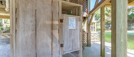 Une structure en bois avec une porte et une affiche accrochée au mur.