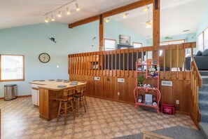 A kitchen with wooden cabinets, a dining area with a table and chairs, and a kitchen island.
