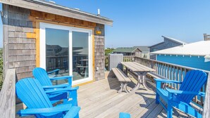 A wooden deck with blue chairs and a picnic table, overlooking a pool. - Semi Oceanfront home in Avon w/ ocean views (Avon)