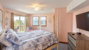 A bedroom with a bed, a ceiling fan, a television, and a window with a view. - Semi Oceanfront home in Avon w/ ocean views (Avon)