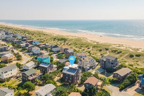 Une zone résidentielle côtière avec des maisons, une plage et un ciel dégagé.