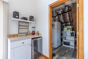 A compact kitchen with a refrigerator, a microwave, and a small countertop with a blender.