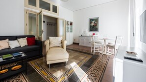 A modern living room with a sofa, armchair, and dining area.