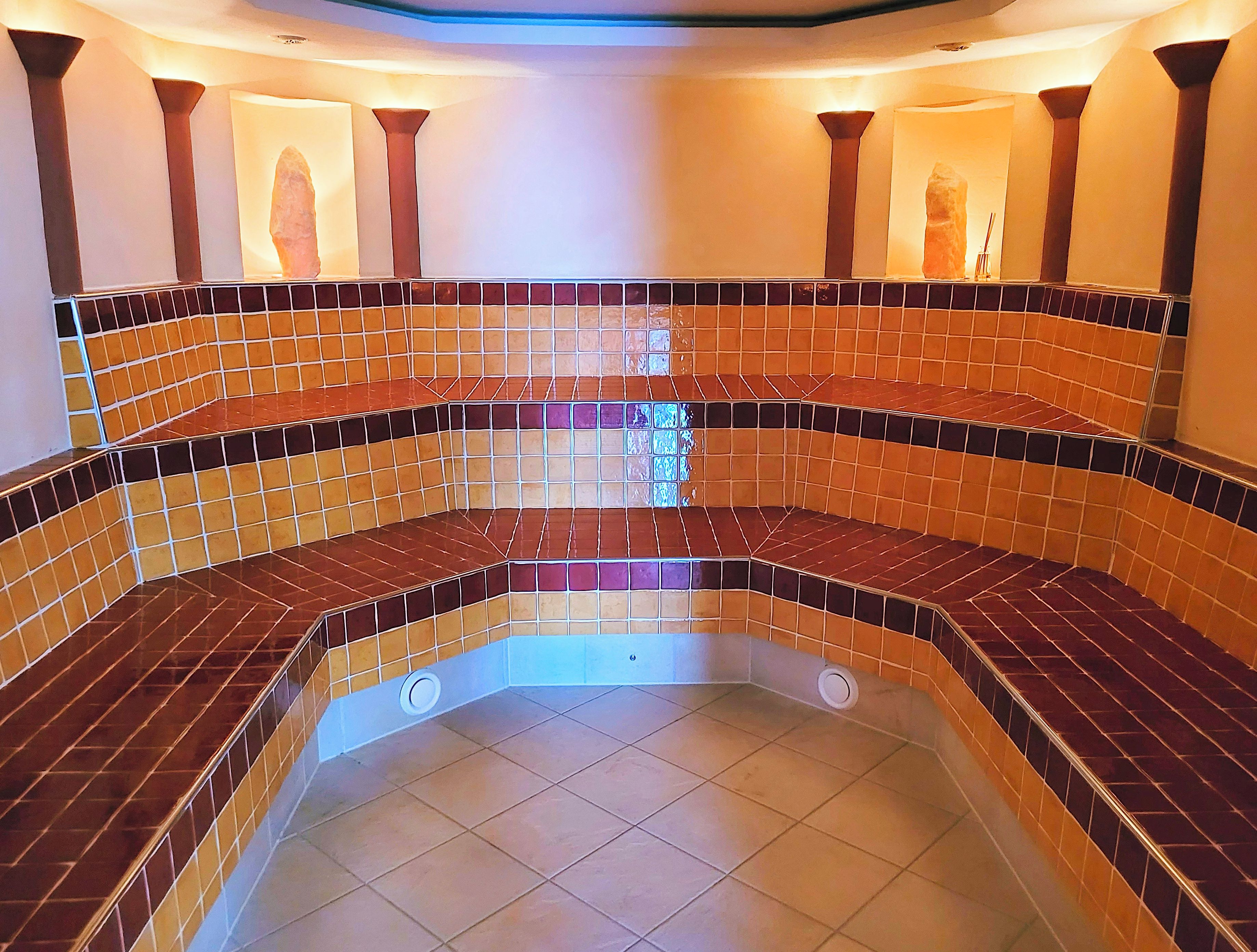 A hot tub area with tiled walls and a central drain.