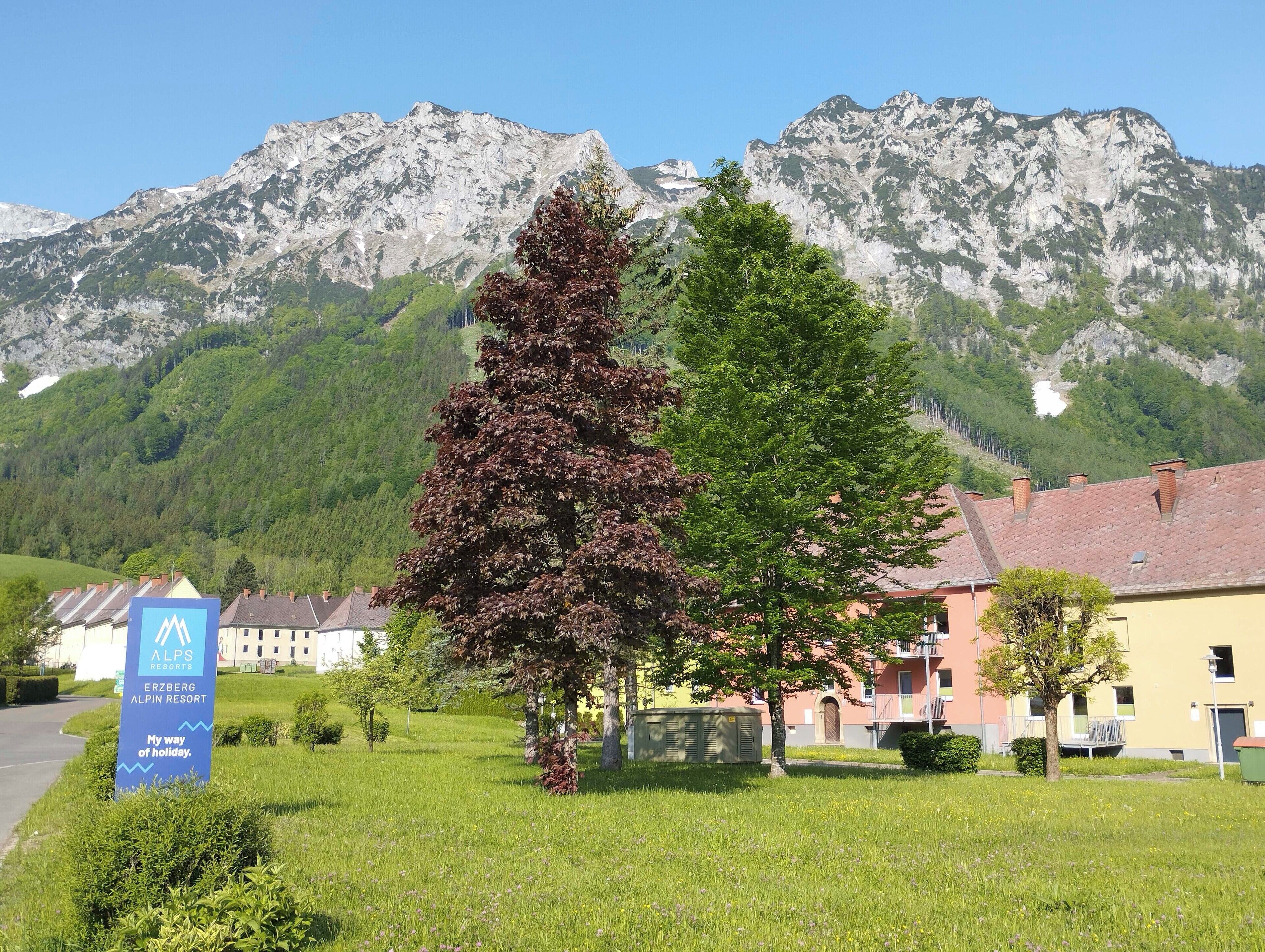 Placa do Erzberg Alpin Resort, com montanhas ao fundo.