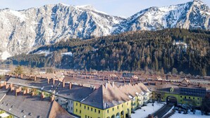 Un pueblo con edificios tradicionales y una montaña al fondo.