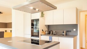 Una cocina moderna con una isla central, horno empotrado y electrodomésticos de acero inoxidable.
