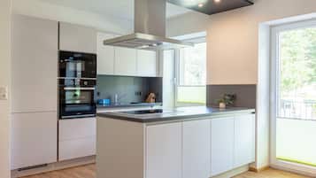 Appartement | Privékeuken | Een koelkast met diepvriezer, een microgolfoven, een kookplaat