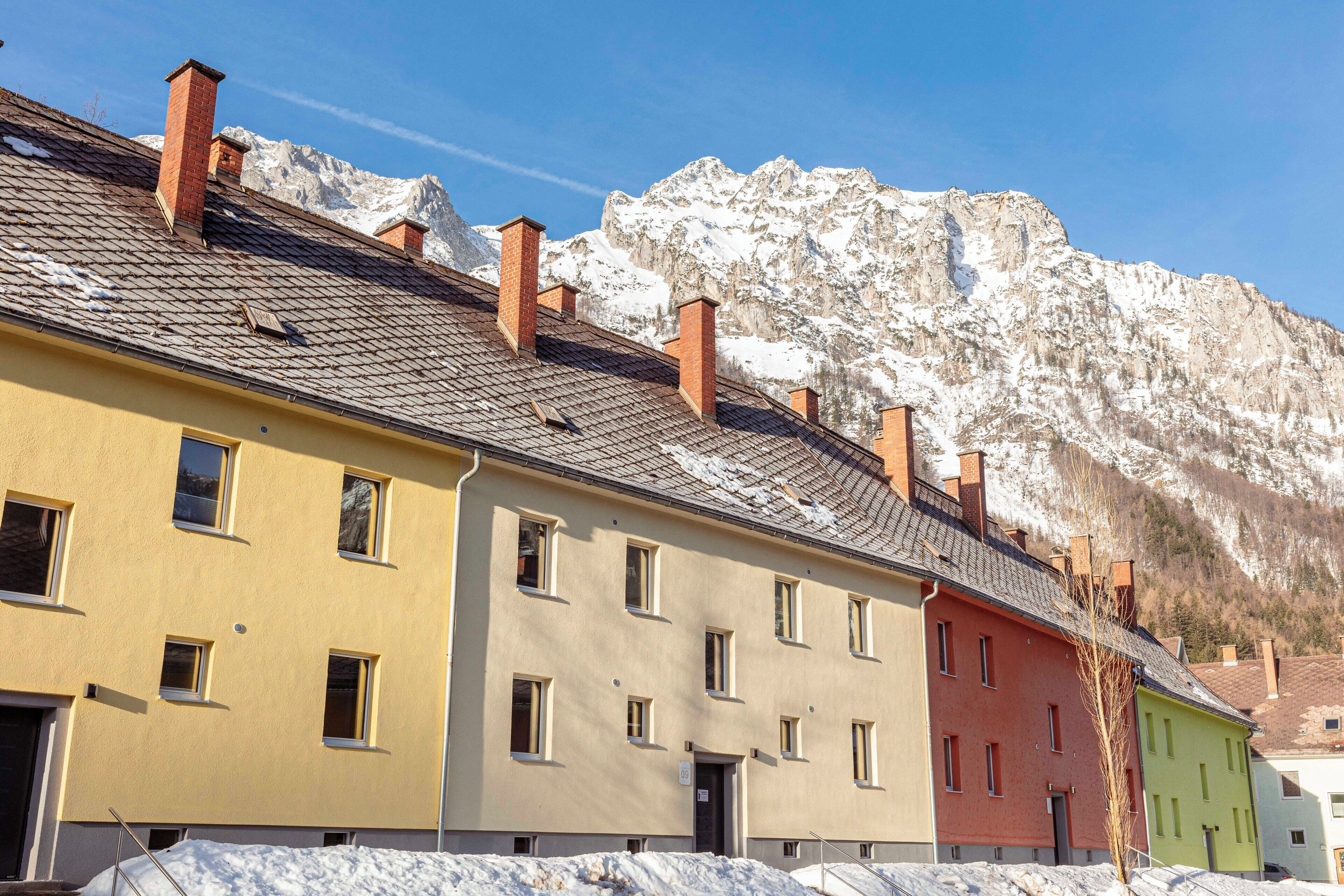 A row of colorful buildings with a mountain backdrop.
