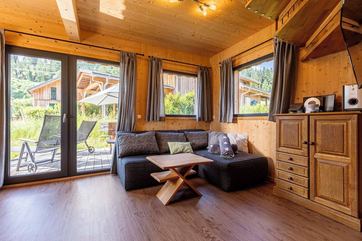 Un interior de madera con un sofá, una mesa de madera y un armario.