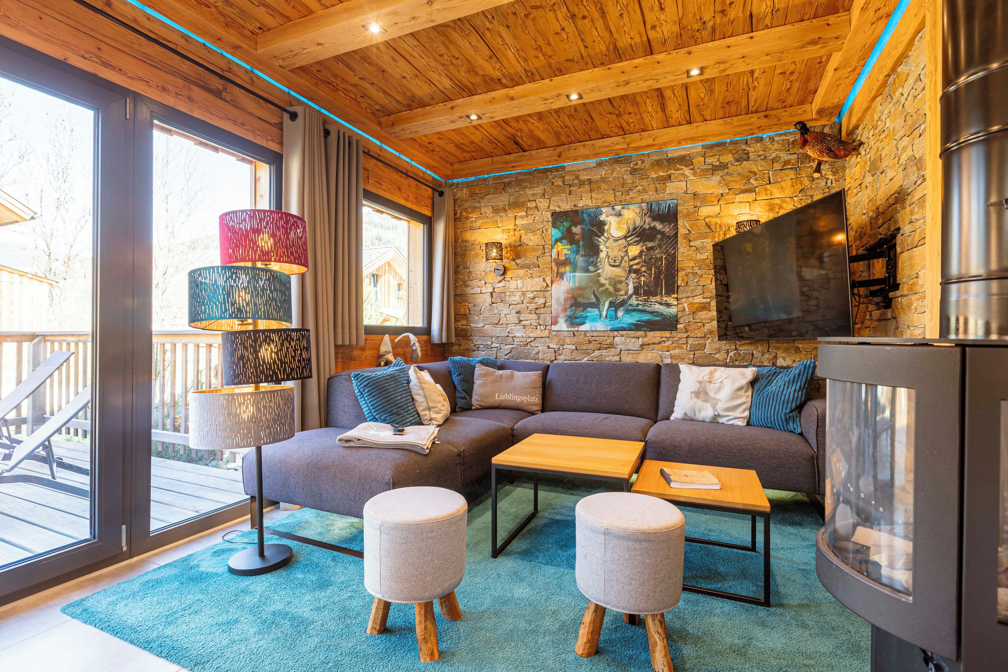 A cozy living room with a stone wall, a large painting, and a modern fireplace.
