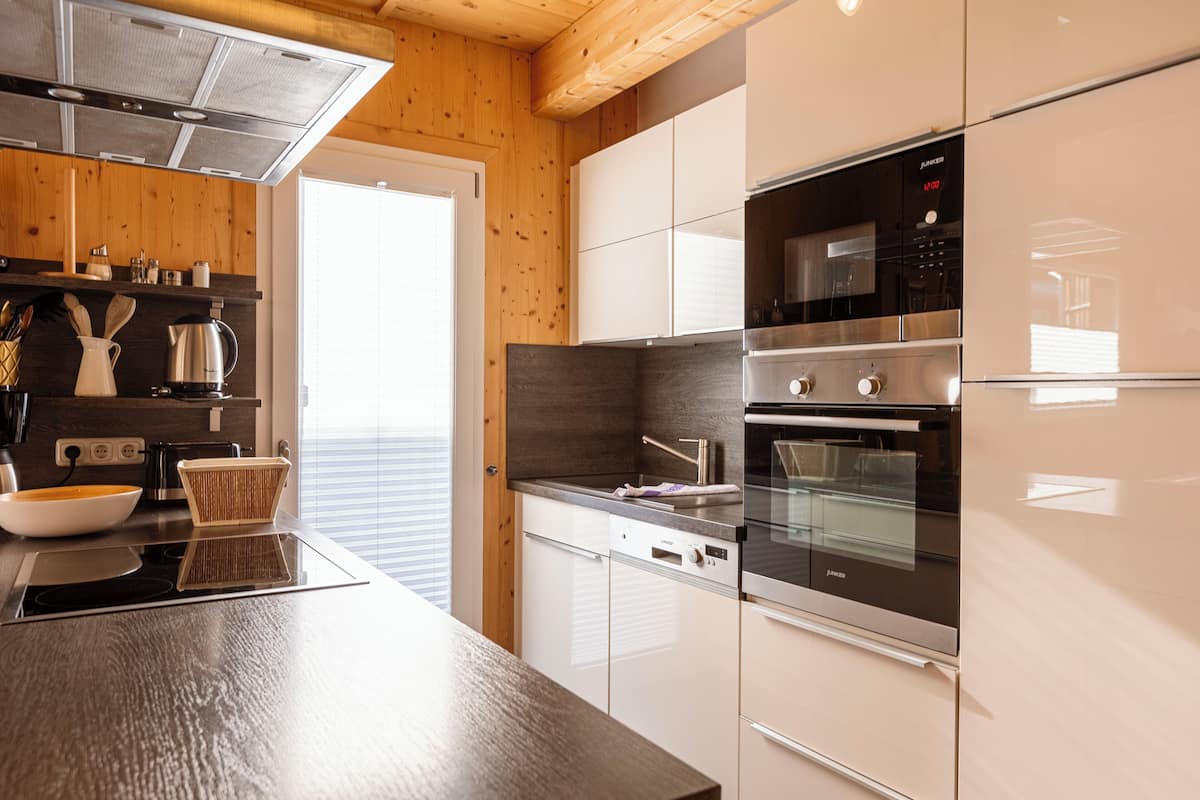 A modern kitchen with stainless steel appliances, wooden cabinetry, and a large island.