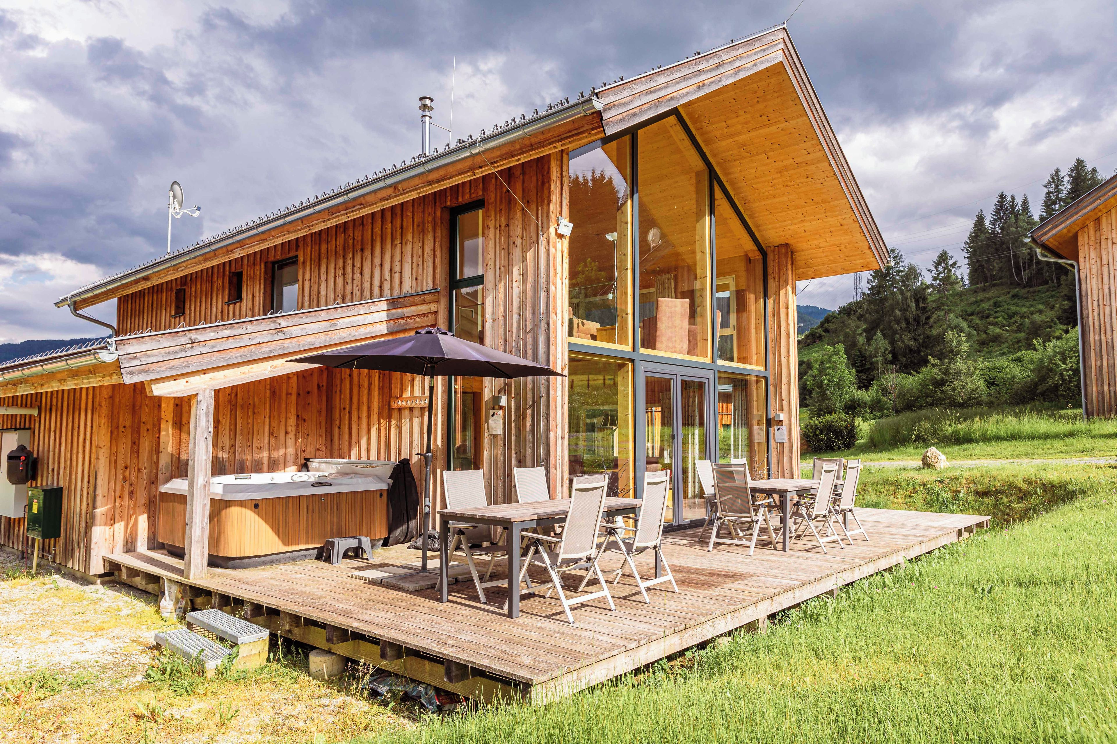 Une cabane en bois dotée d’une terrasse, d’un espace salon extérieur et d’un jacuzzi.
