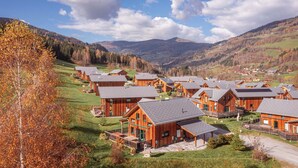 A cluster of wooden cabins with a view of a mountainous landscape. - Kreischberg Chalets by ALPS RESORTS (Sankt Georgen am Kreischberg)