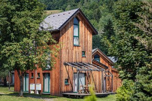 A wooden cabin with a large porch, multiple windows, and a sloped roof. - Ferienpark Kreischberg (Sankt Georgen am Kreischberg)