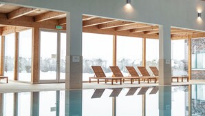 A spa area with wooden loungers and a glass pool reflecting the surroundings. - Ferienpark Kreischberg (Sankt Georgen am Kreischberg)