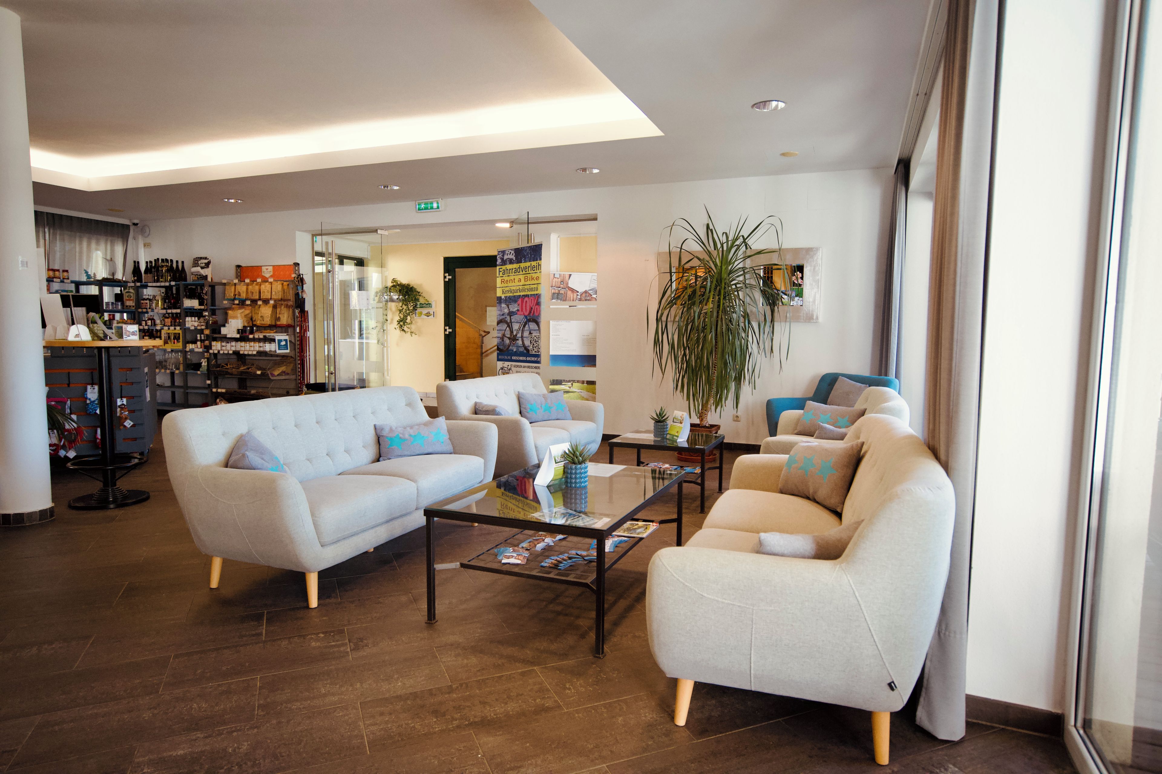 Eine Hotelhalle mit Sitzgelegenheiten, einem Couchtisch und einem Barbereich mit verschiedenen Gegenständen.