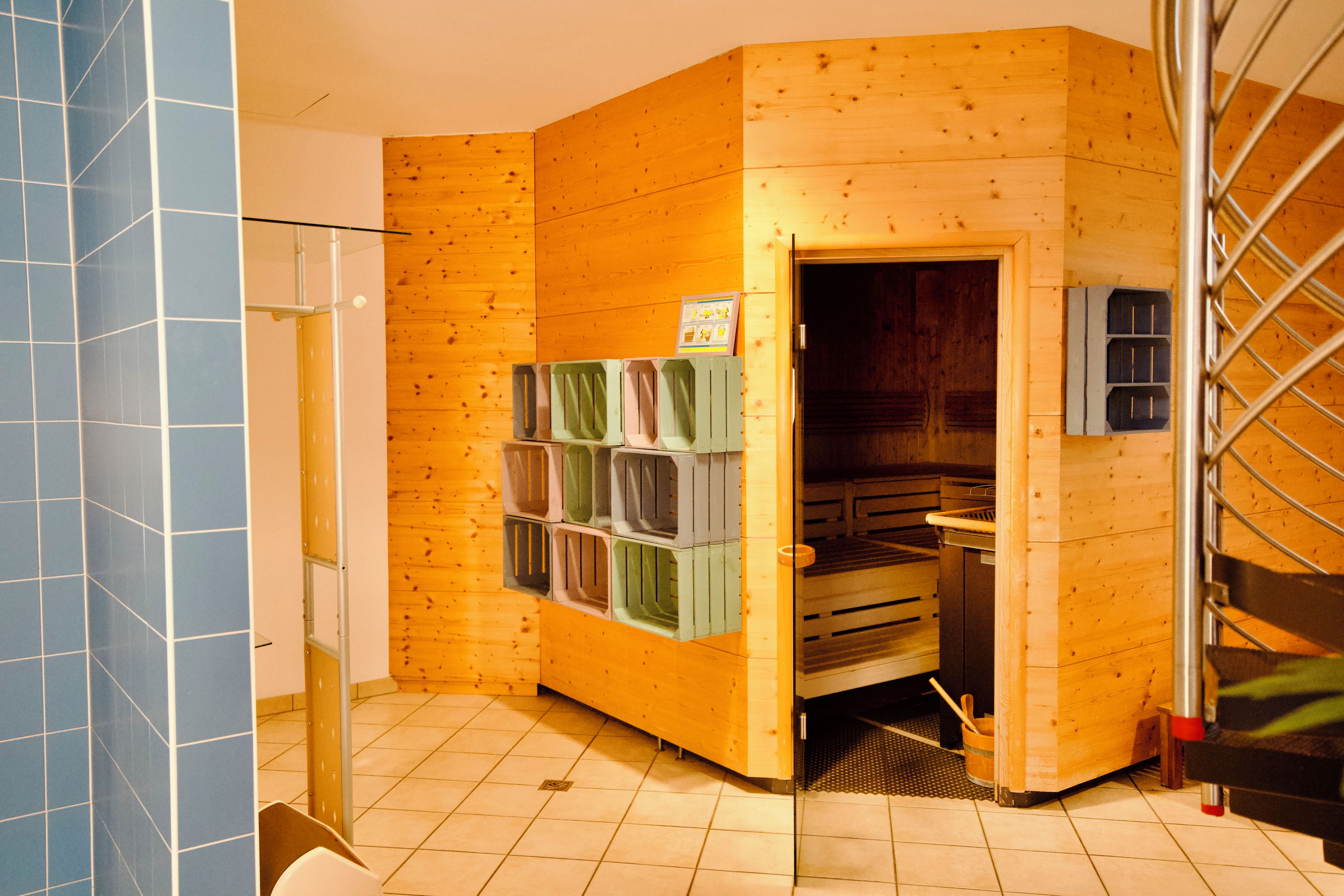 Une pièce d’angle avec des murs en bois, un sol carrelé et une porte donnant sur une autre pièce.