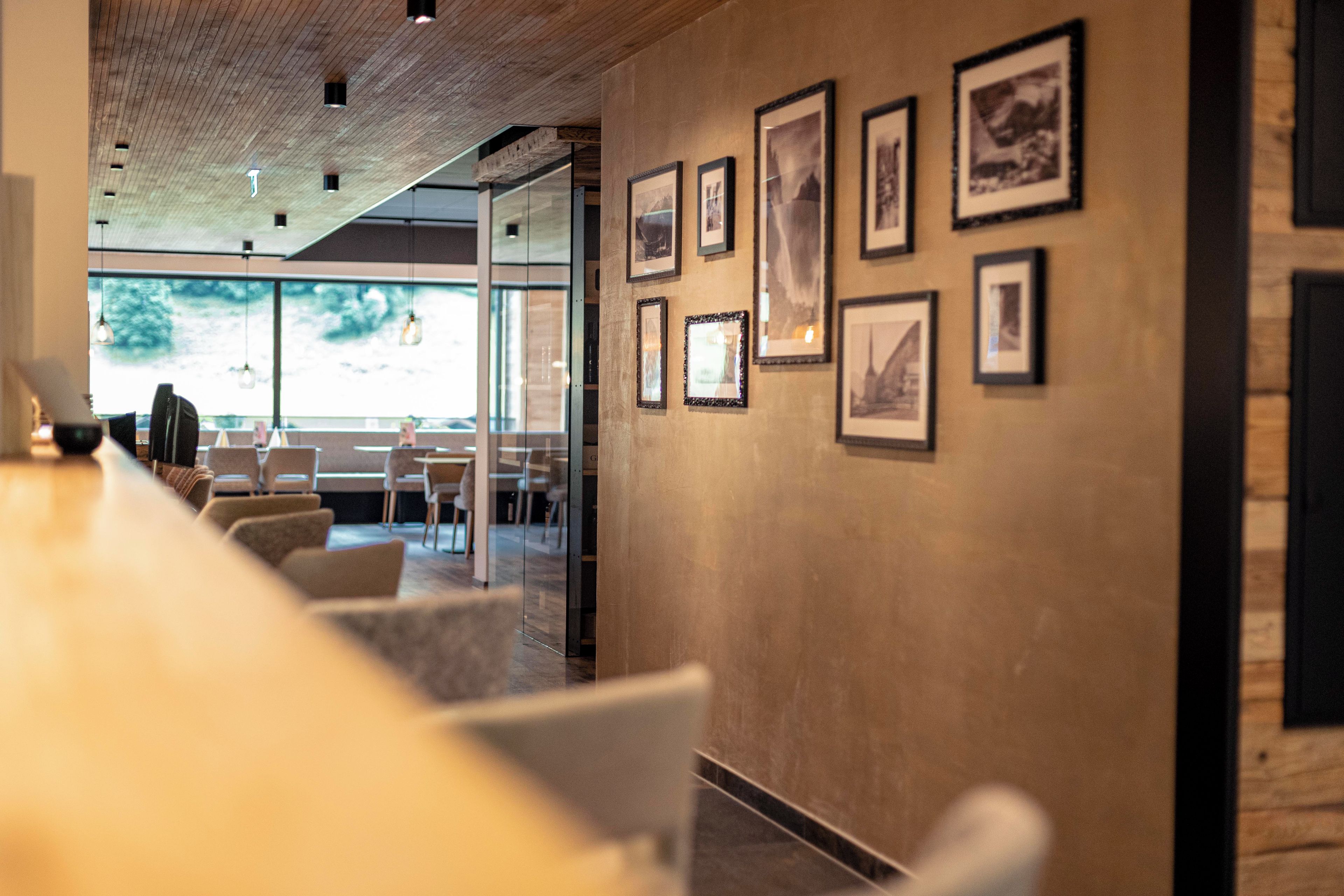 A modern interior with a bar area, seating, and framed pictures on the wall.