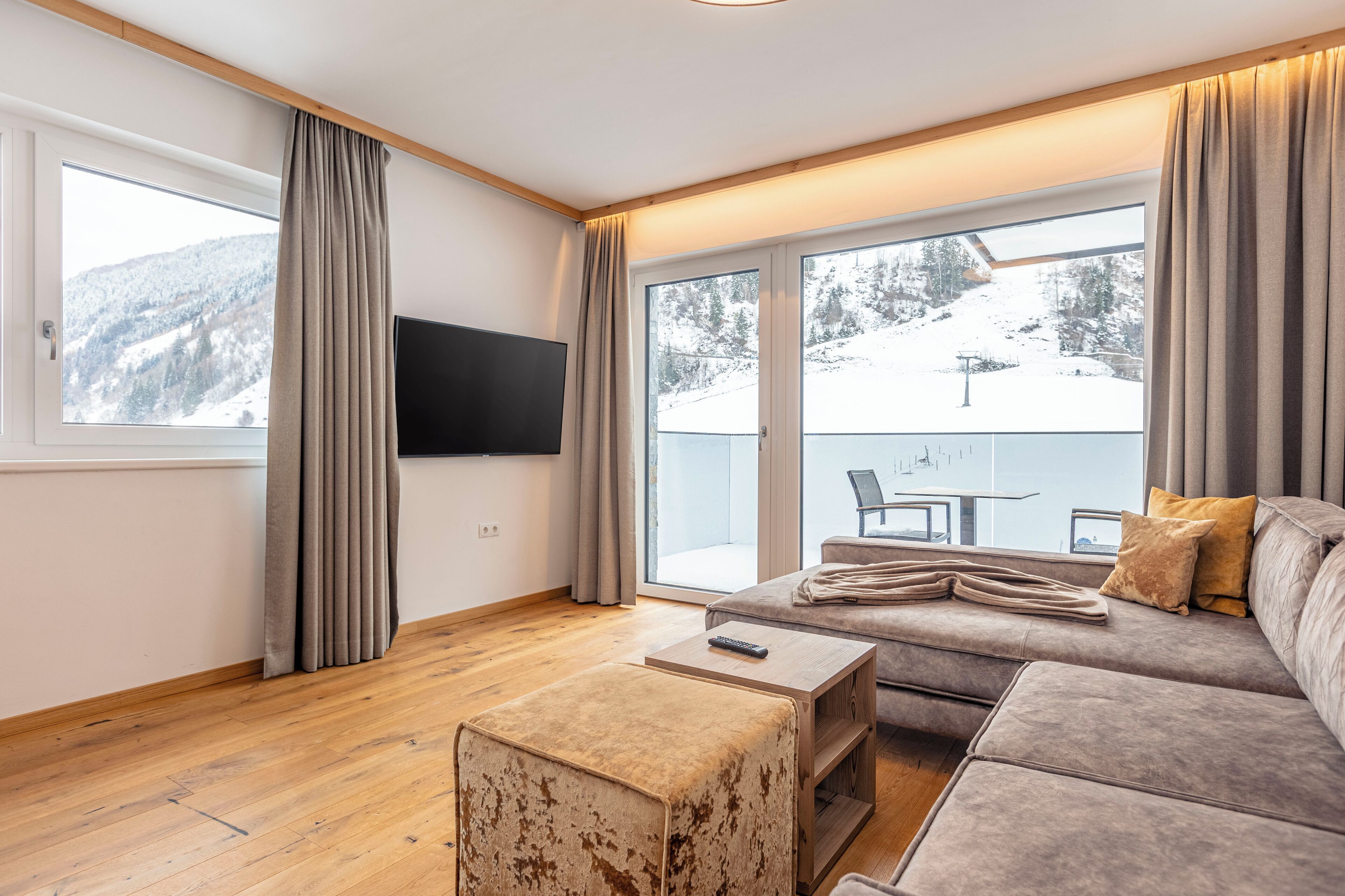 A modern living room with a sofa, a coffee table, and a TV.