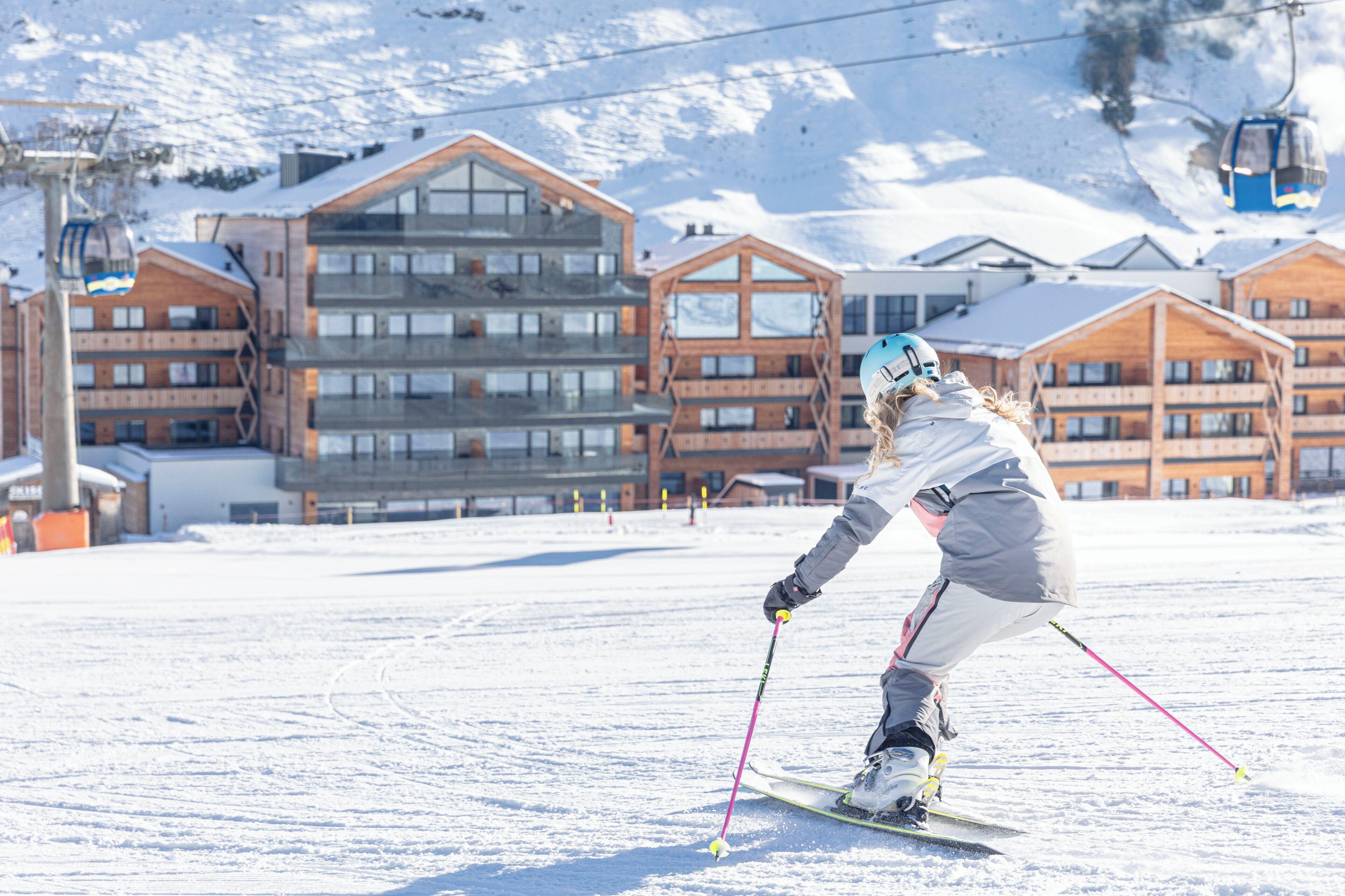 A ski resort with modern buildings, ski slopes, and a ski lift.