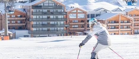 A ski resort with modern buildings, ski slopes, and a ski lift.