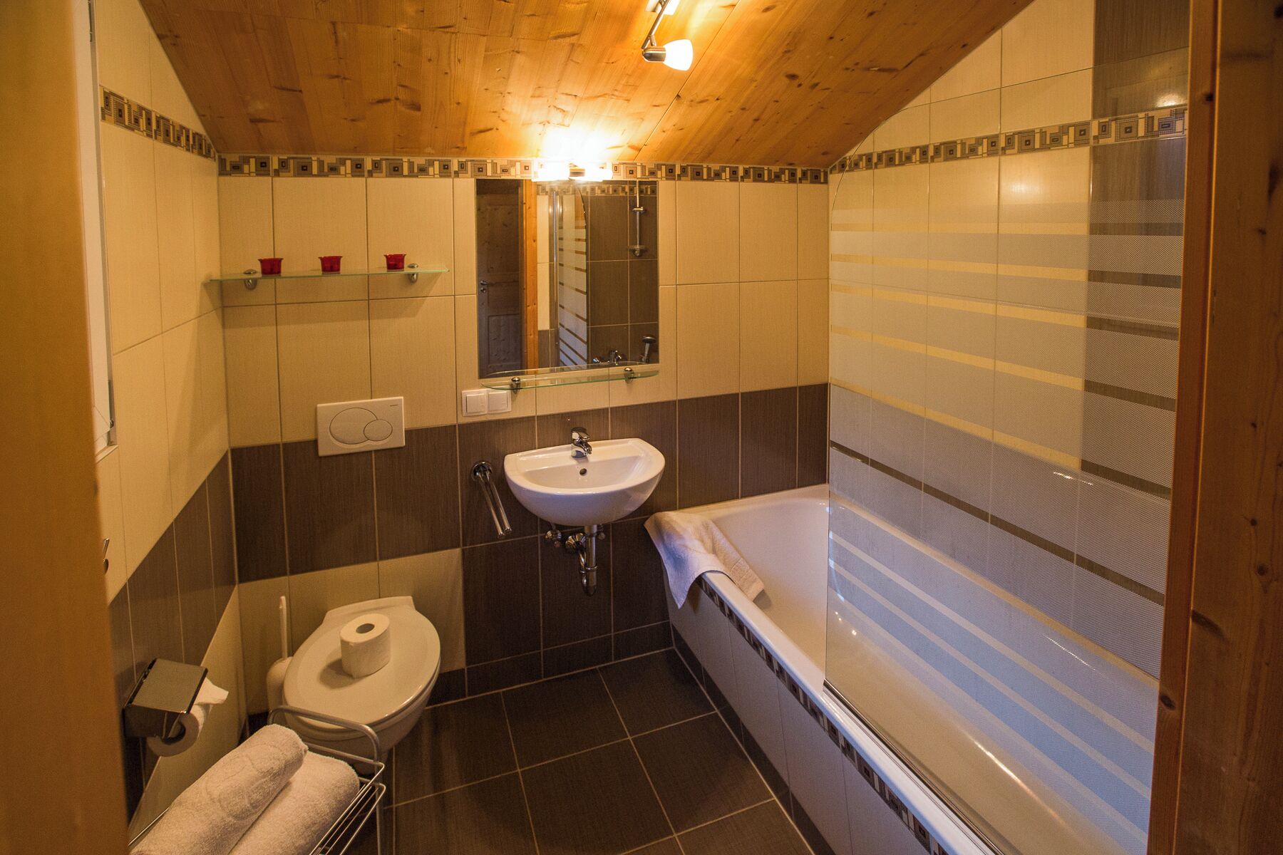 Ein Badezimmer mit Holzboden, Waschbecken, Toilette und Badewanne.