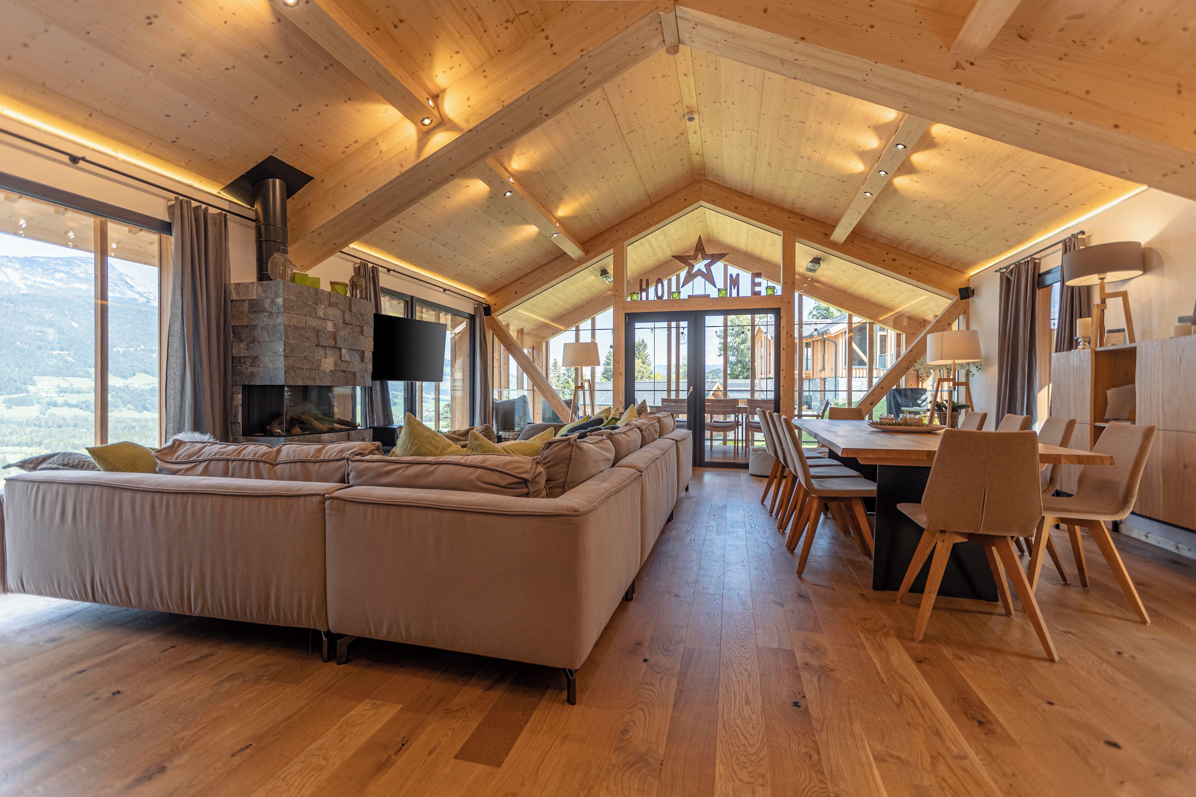 Un vaste espace de vie comprenant un grand canapé, un plancher en bois et une cheminée.