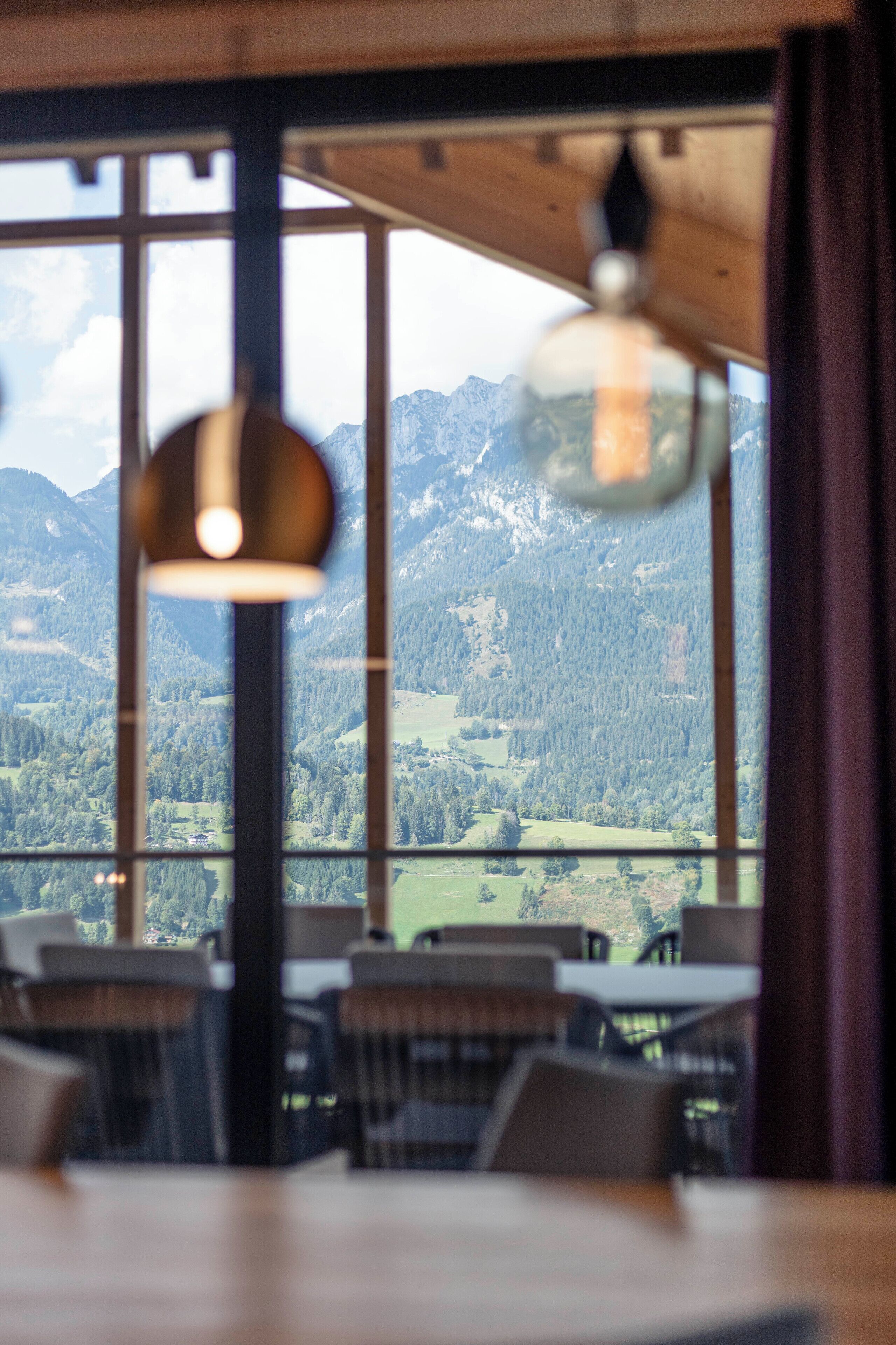 A dining area with a view of mountains through large windows.