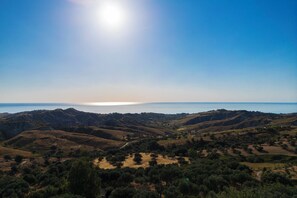 A panoramic view of a coastal landscape with rolling hills and a clear sky.