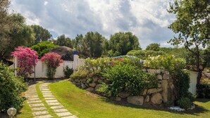 A stone pathway leading to a house with a stone wall and lush greenery. - Villa Acquaro Santa Caterina  (Santa Caterina dello Ionio)