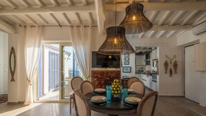 Un coin repas avec une table ronde, des chaises et un vase rempli de citrons.