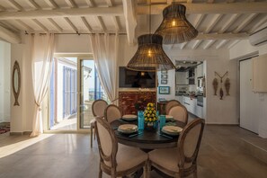 A dining area with a round table, chairs, and a vase of lemons. - Villa Acquaro Santa Caterina  (Santa Caterina dello Ionio)
