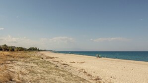 A beach with a clear sky, sandy shore, and sparse vegetation. - Villa Acquaro Santa Caterina  (Santa Caterina dello Ionio)