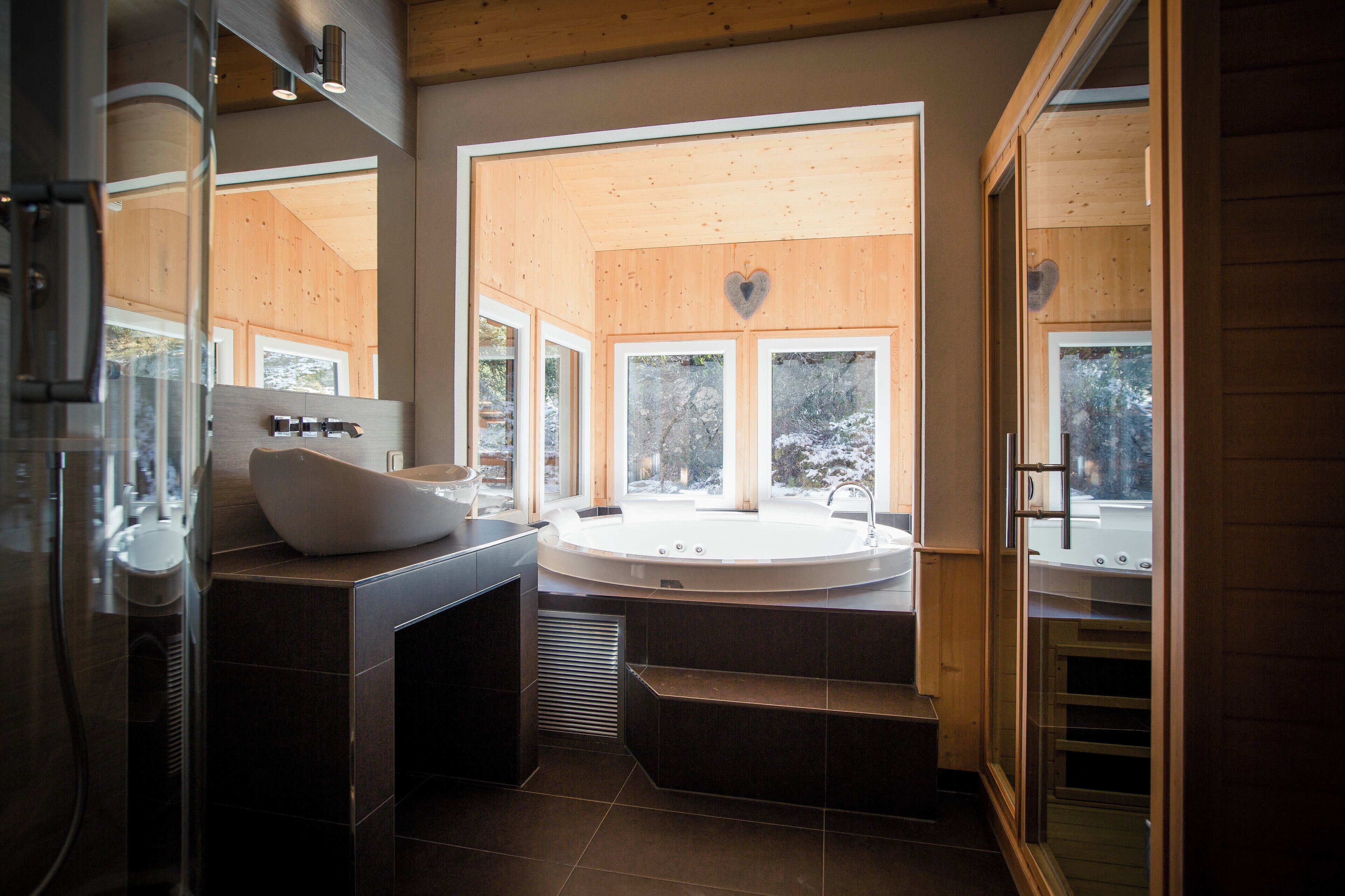 Une salle de bain moderne avec une baignoire sur pieds, une grande fenêtre et une douche à parois de verre.