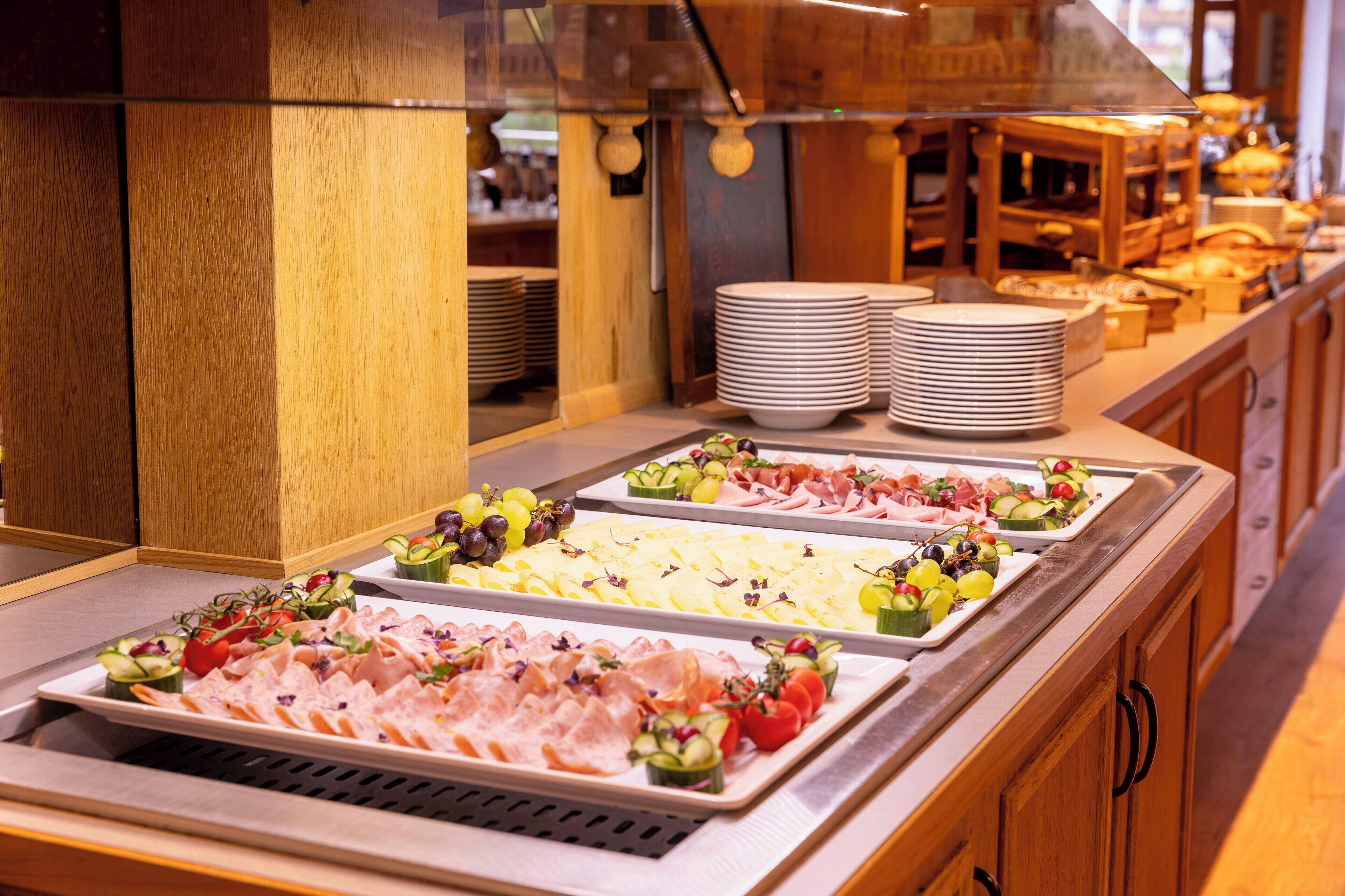 Een buffet met diverse gerechten en borden.