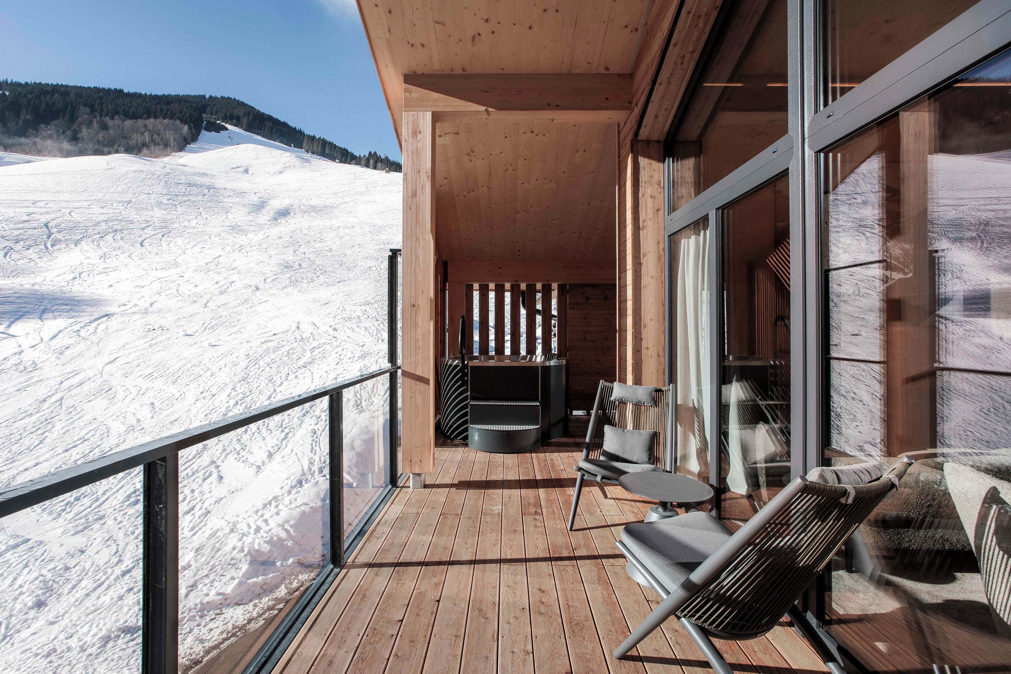 A wooden balcony with a view of a snowy mountain.