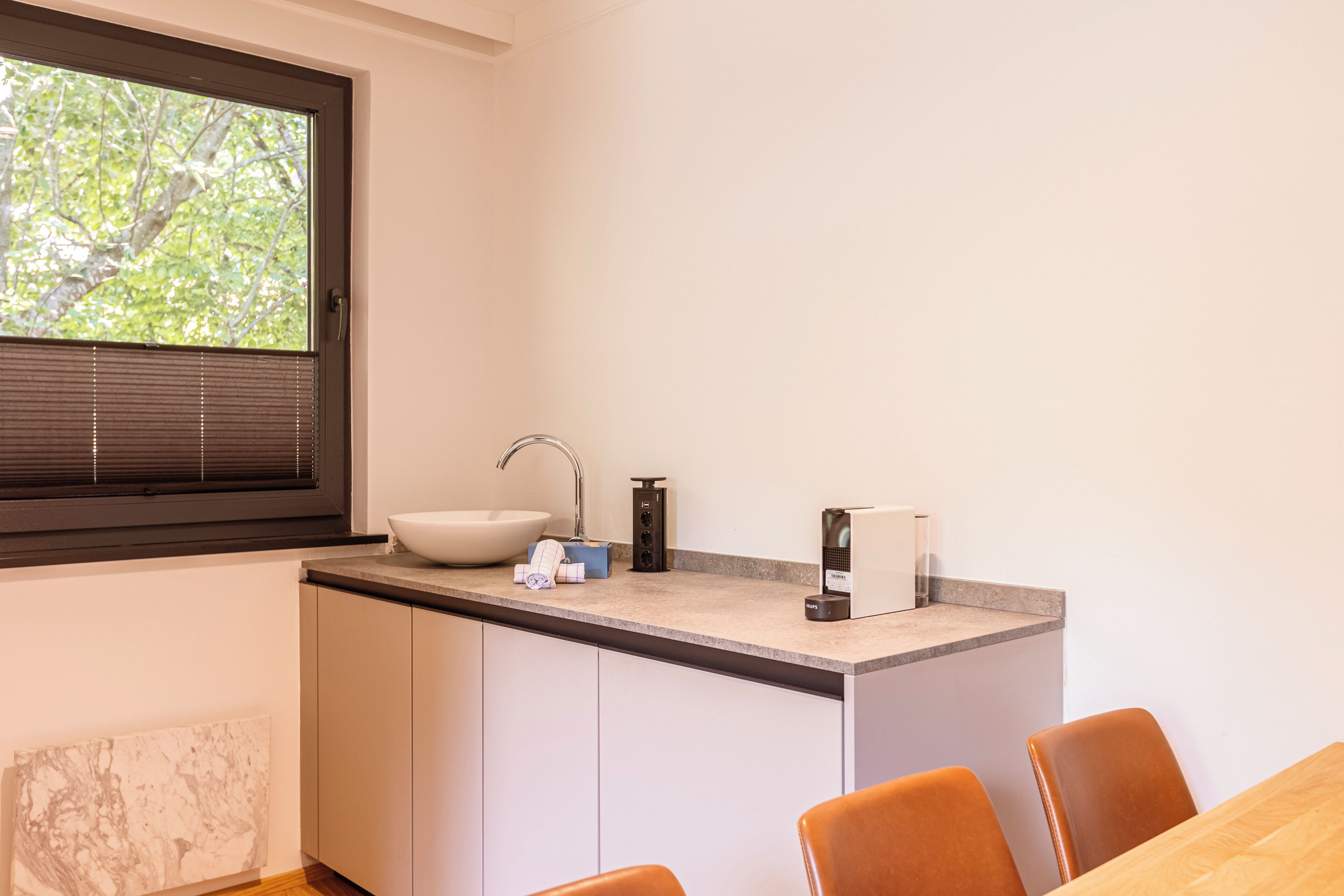 Una cocina moderna con un amplio ventanal, un fregadero y una encimera con varios electrodomésticos.