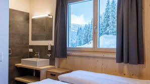 A modern bathroom with a sink, mirror, and wooden accents.