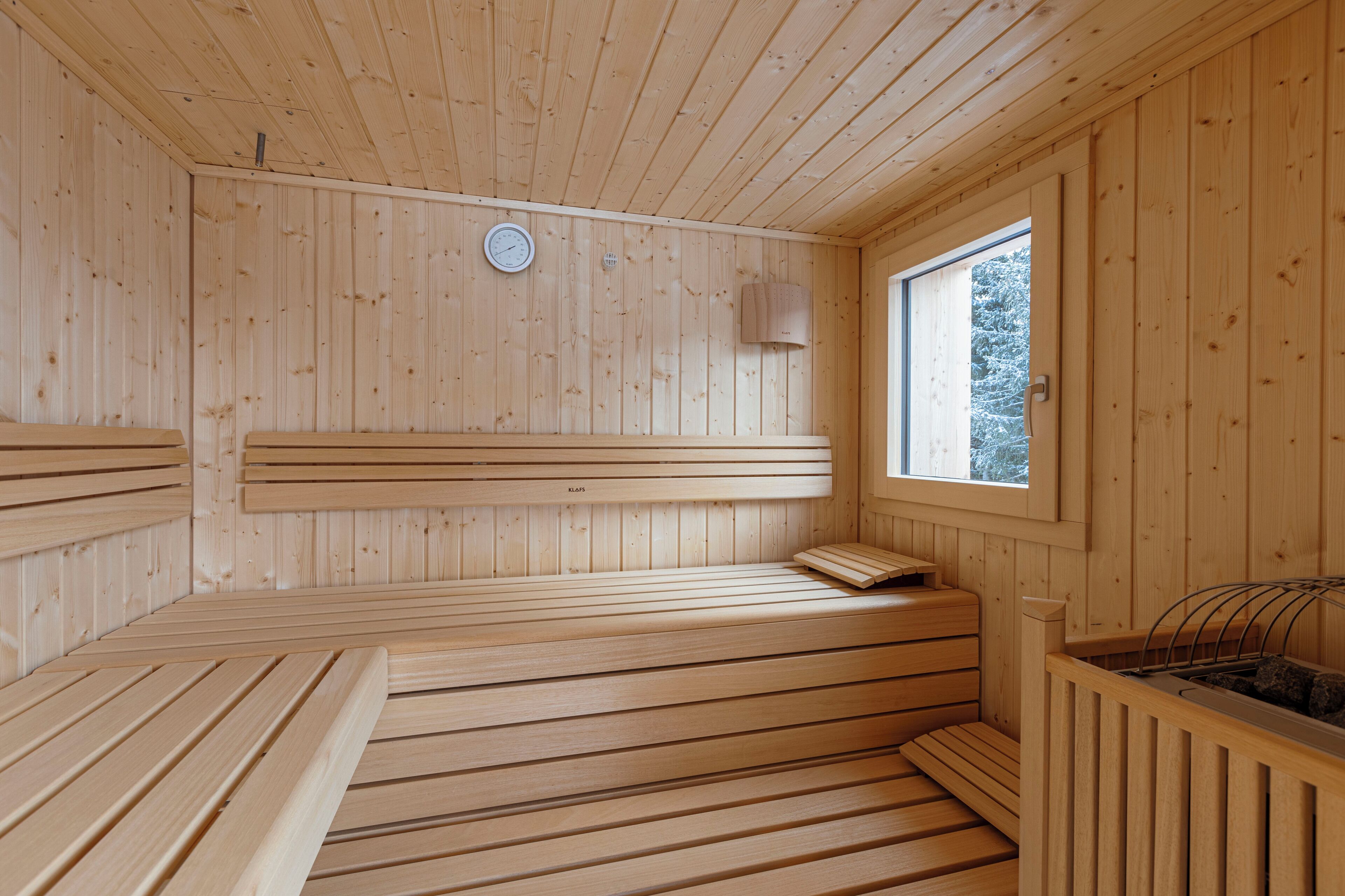 Un sauna de madera con bancos y una ventana.