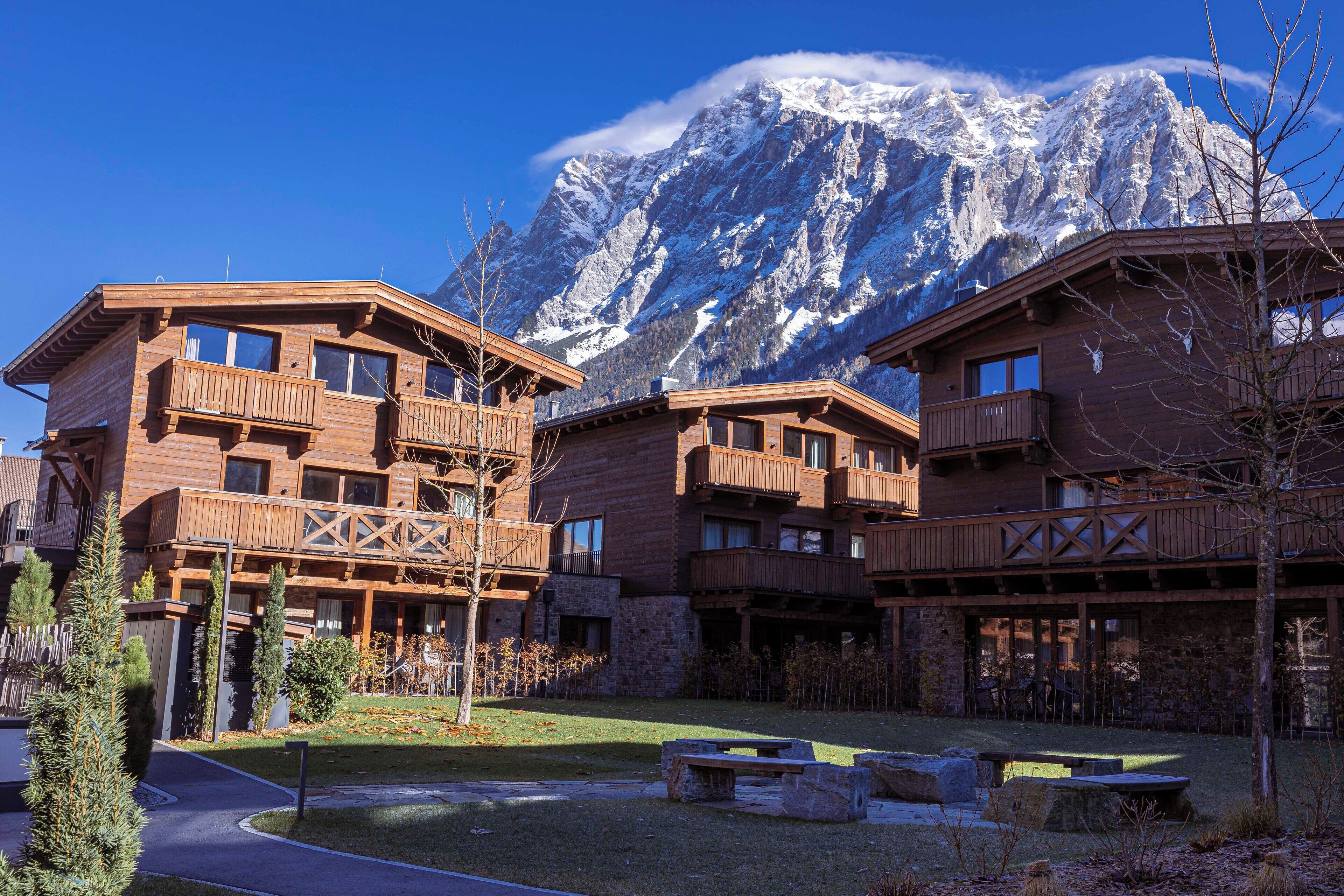 A wooden lodge with balconies and a view of snow-capped mountains.