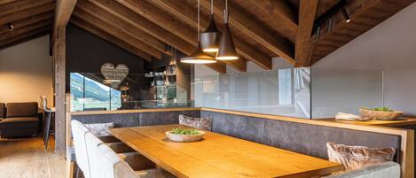 Una cocina moderna con techo de madera, una isla grande con asientos e iluminación colgante.