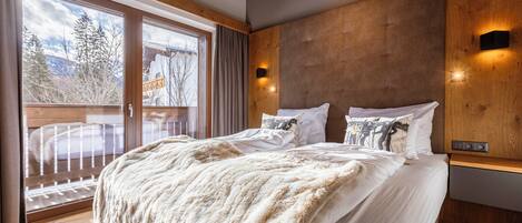 Un dormitorio con una cama grande, cabecera de madera y vistas a un balcón.