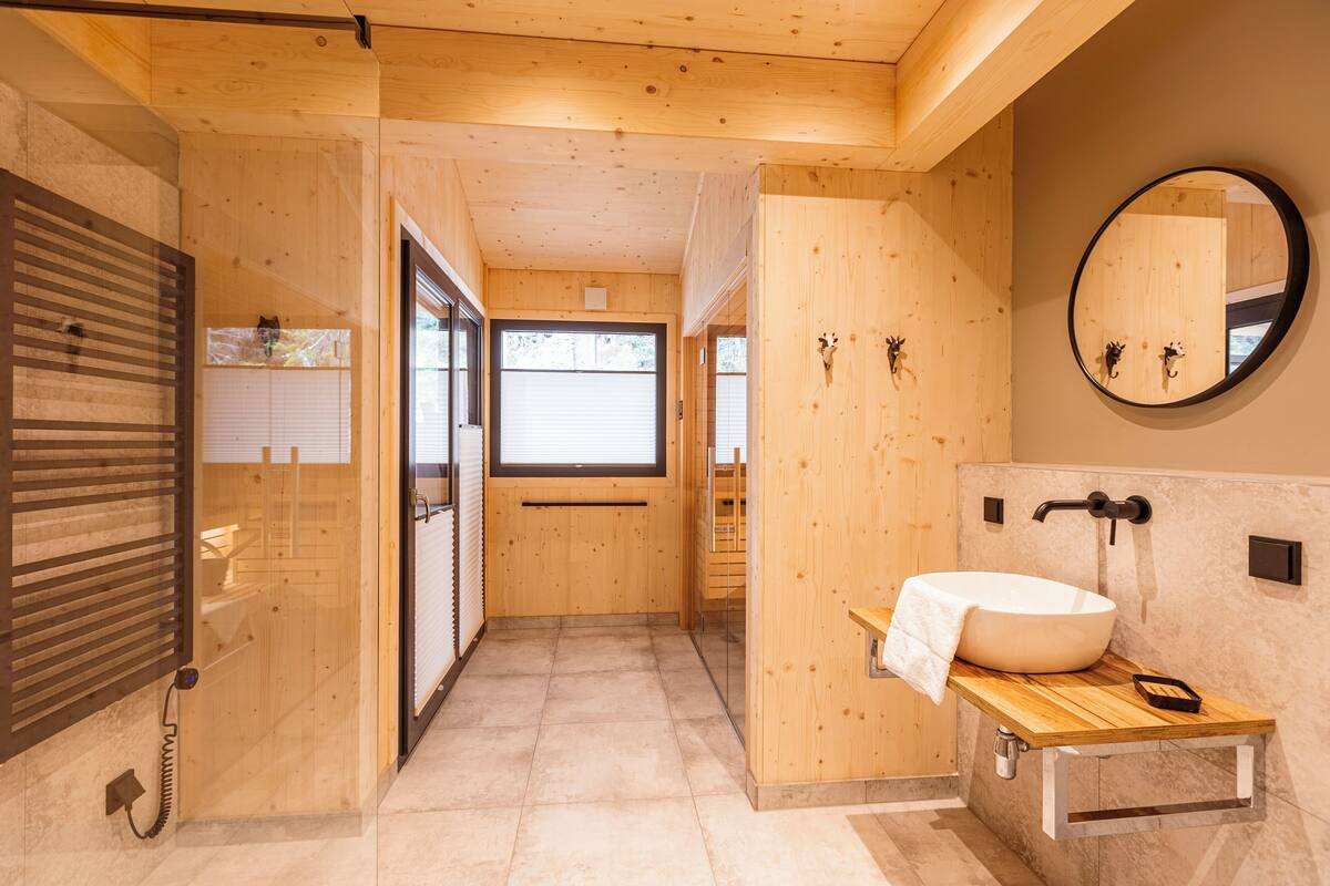 A modern bathroom with a wooden interior, a large mirror, and a vessel sink.
