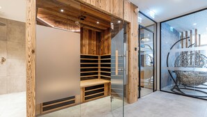 Un intérieur moderne avec un mur en bois, une cloison en verre et un espace salon agrémenté d’une sculpture géométrique originale.