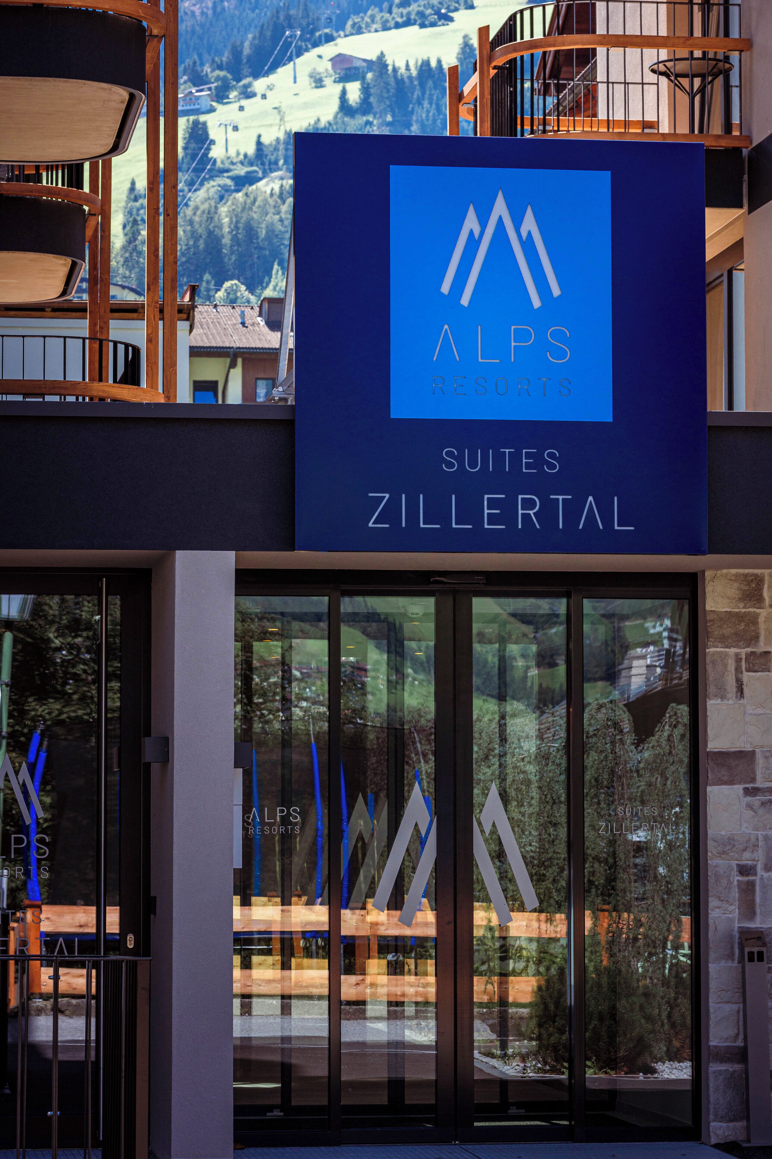 Une enseigne d’hôtel portant le nom « ALPS Resorts Suites Zillertal ».